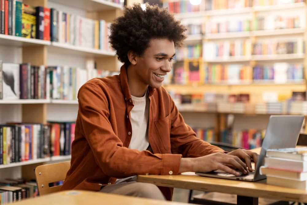 Student lernt mit Laptop in der Bibliothek